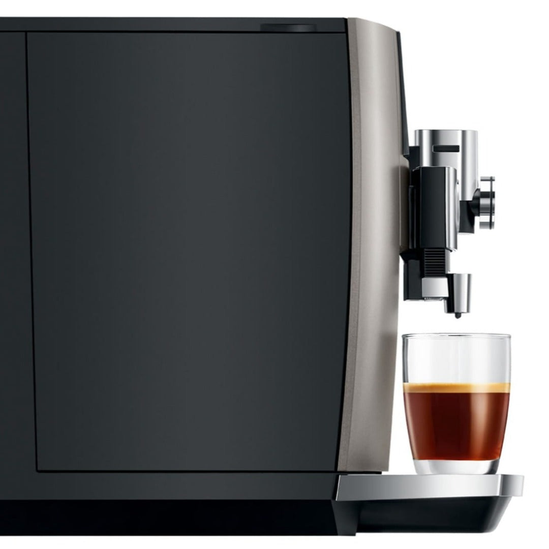 "Jura J8's coffee spout dispensing coffee into a glass cup"